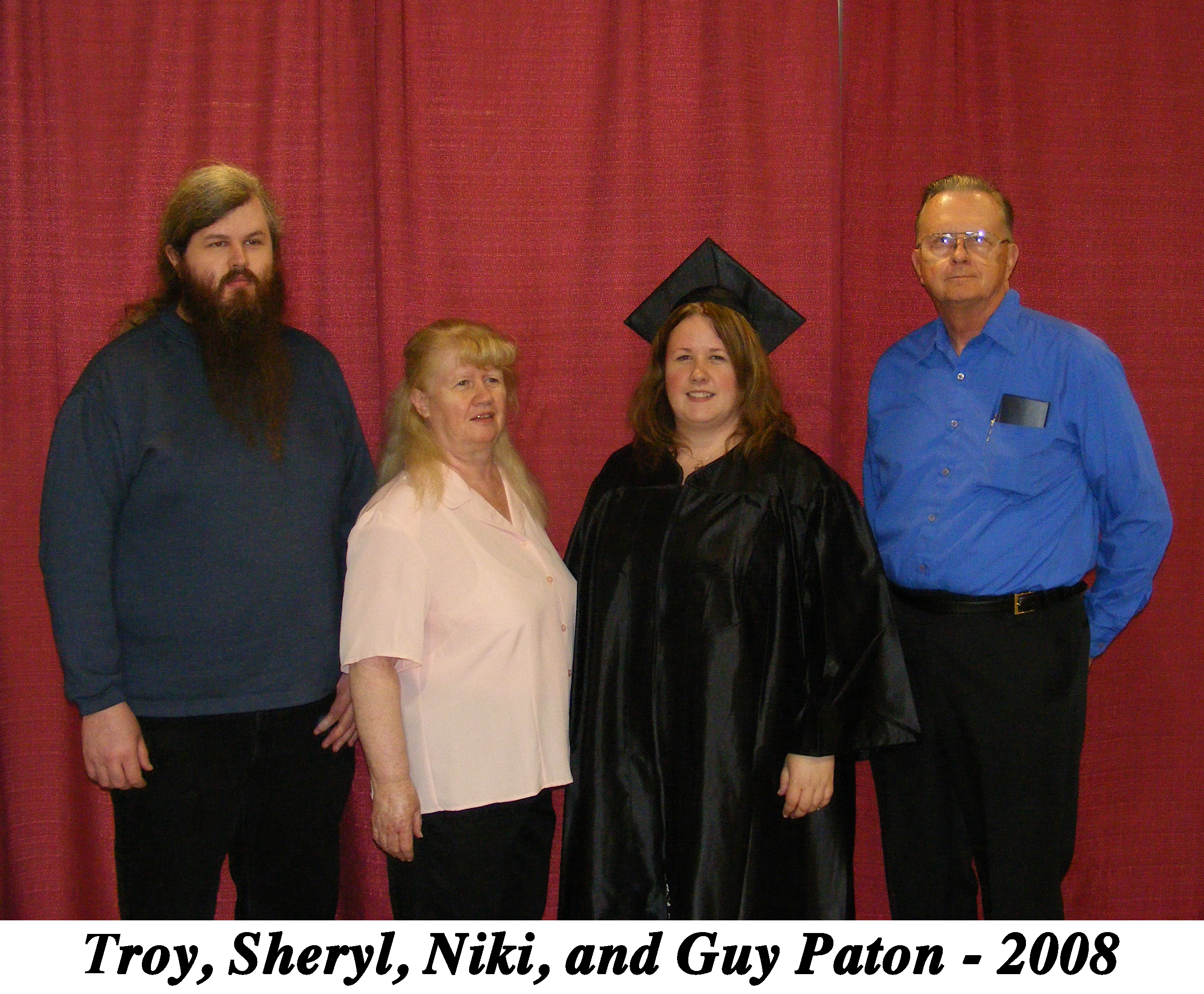The family standing in front of a red curtain.