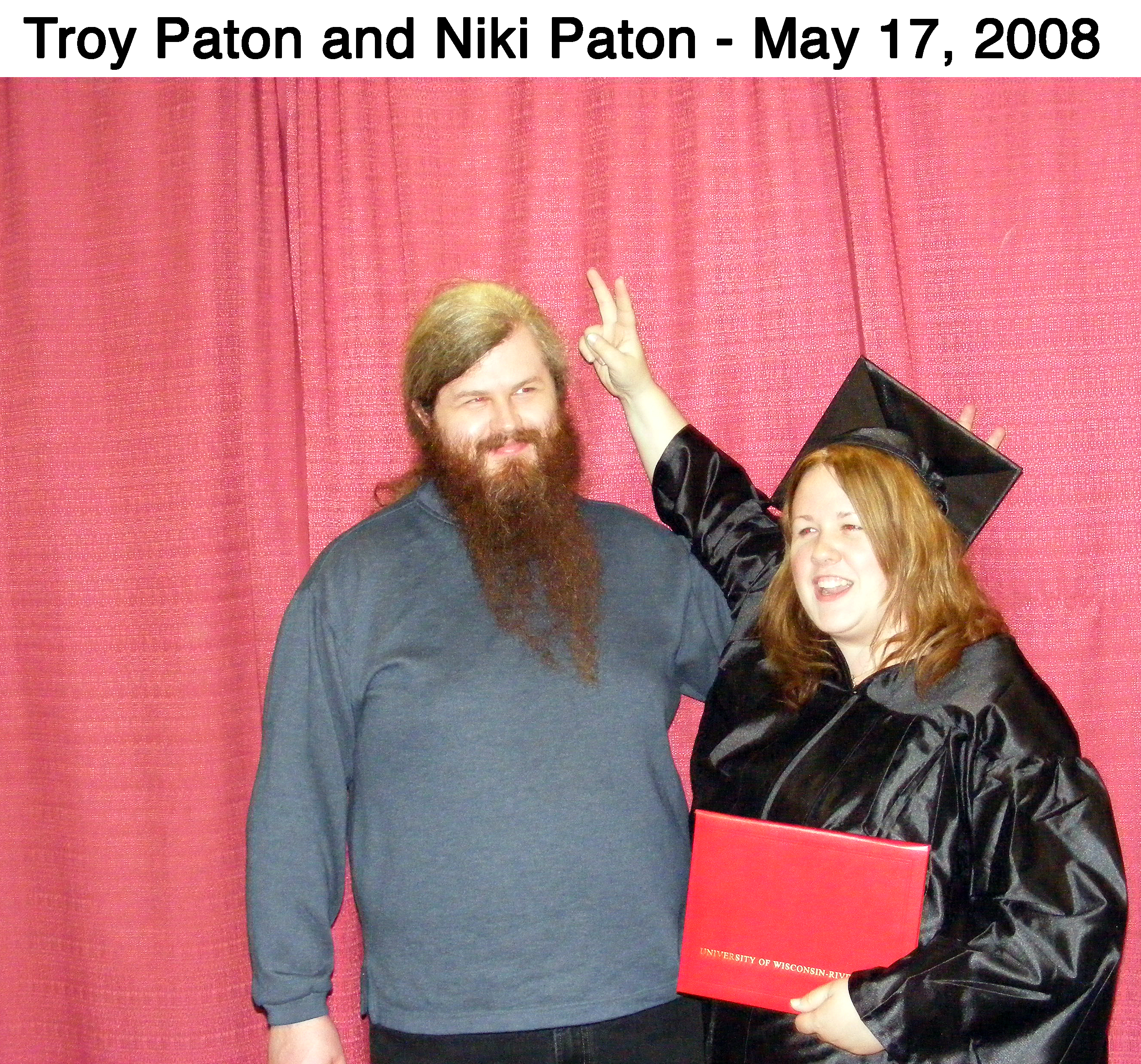 Troy and Niki Paton clowning at her graduation in front of red drapes