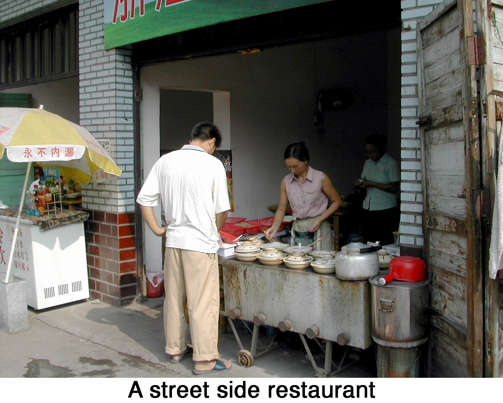 An open-front room serving as a restaurant with bowls of food on a table