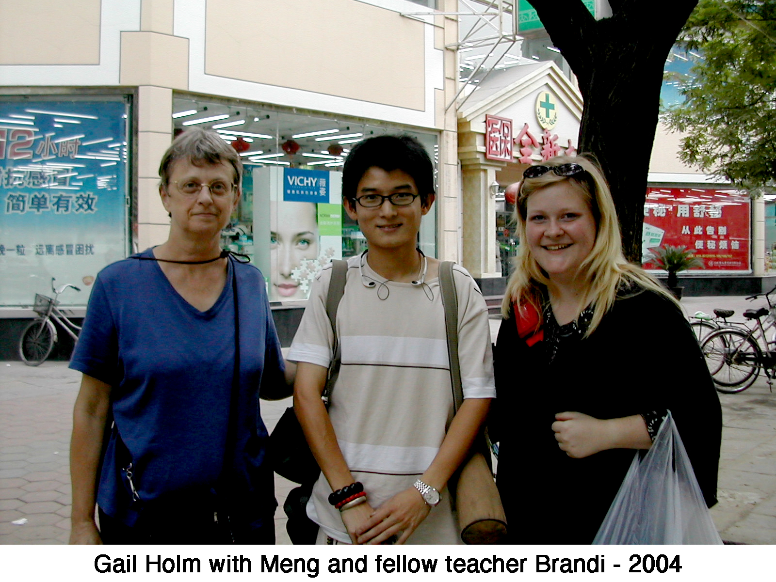 Gail Holm, helper Meng, and fellow teacher Brandi standing on a street