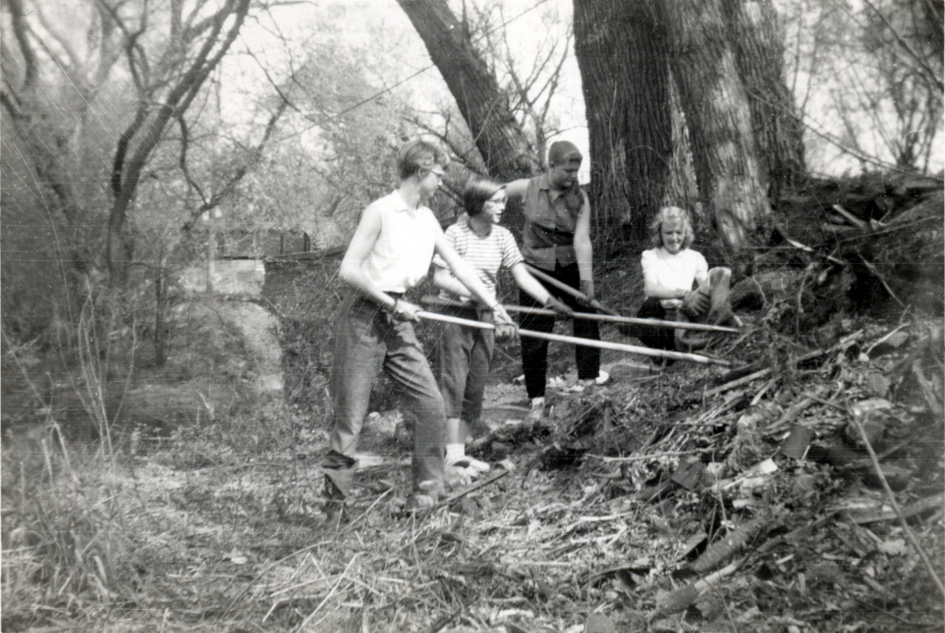 Gail Paton and three friends with rakes and shovels are cleaning the 
              bank of the stream