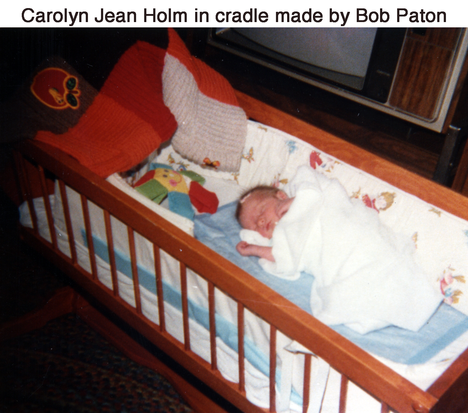 Infant CJ Holm sleeping in the wooden cradle