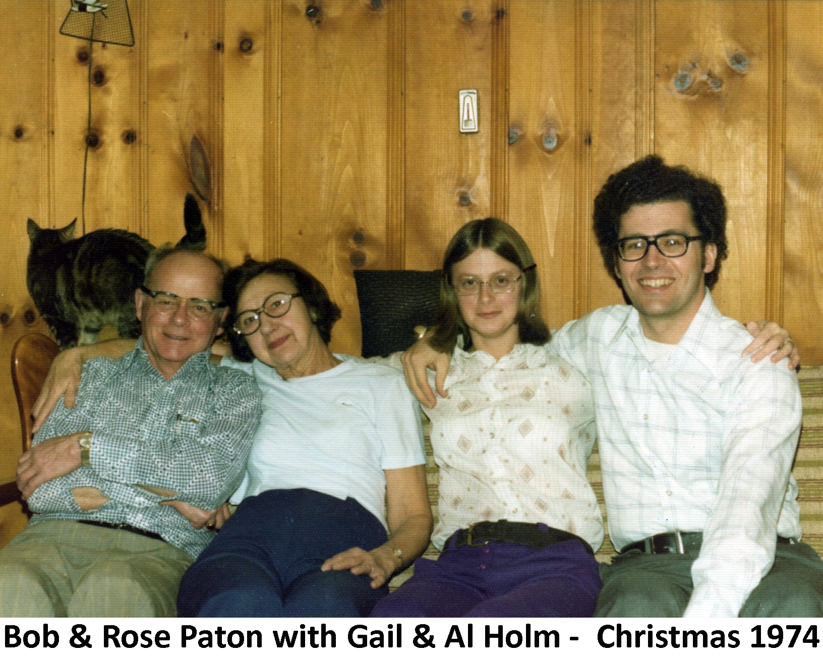 Robert and Rose Paton sitting with their daughter Gail and her husband 
           with Albert Holm with a wood-paneled wall and a cat behind them