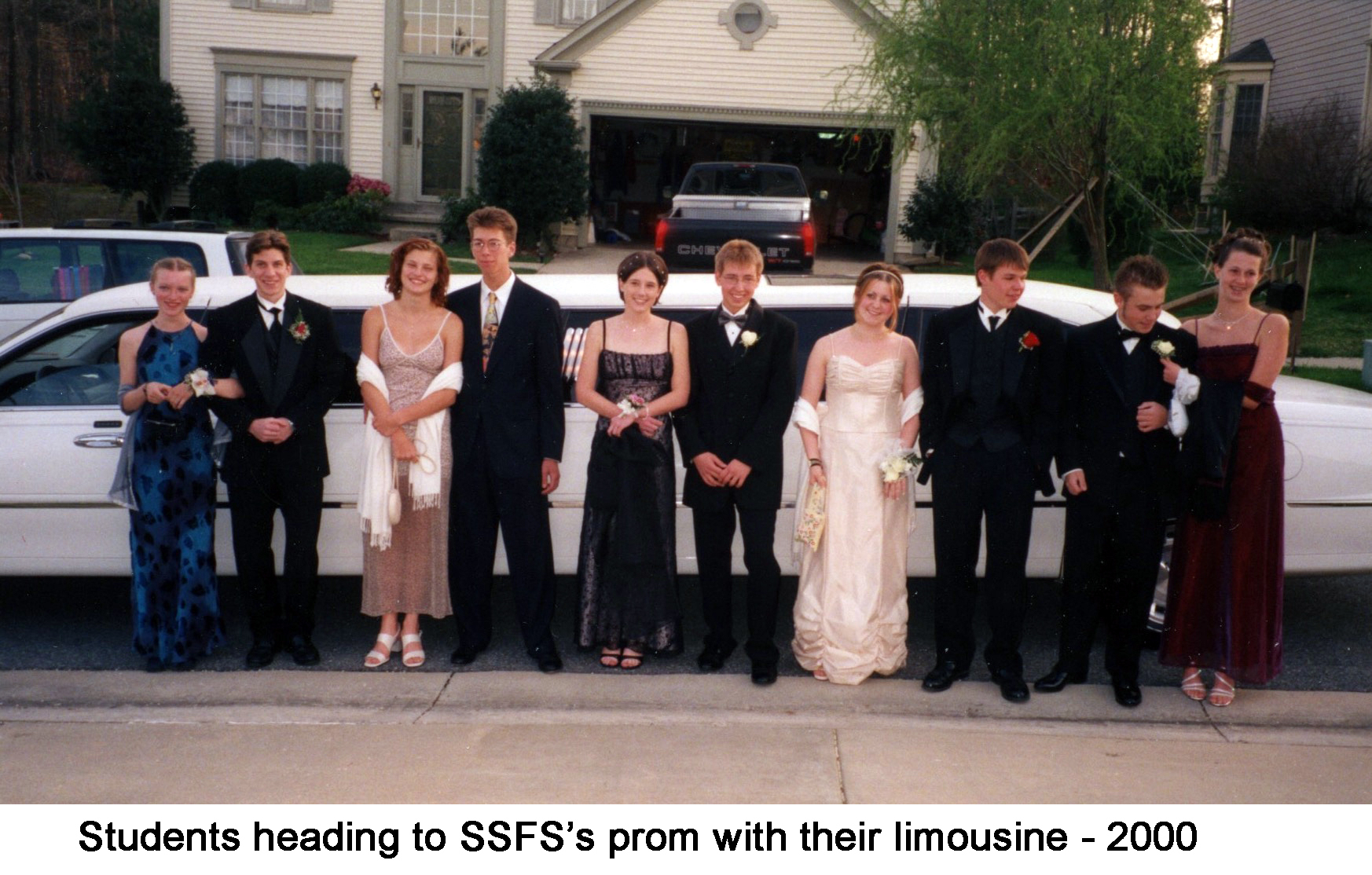 Five couples standing in front of the long white limo