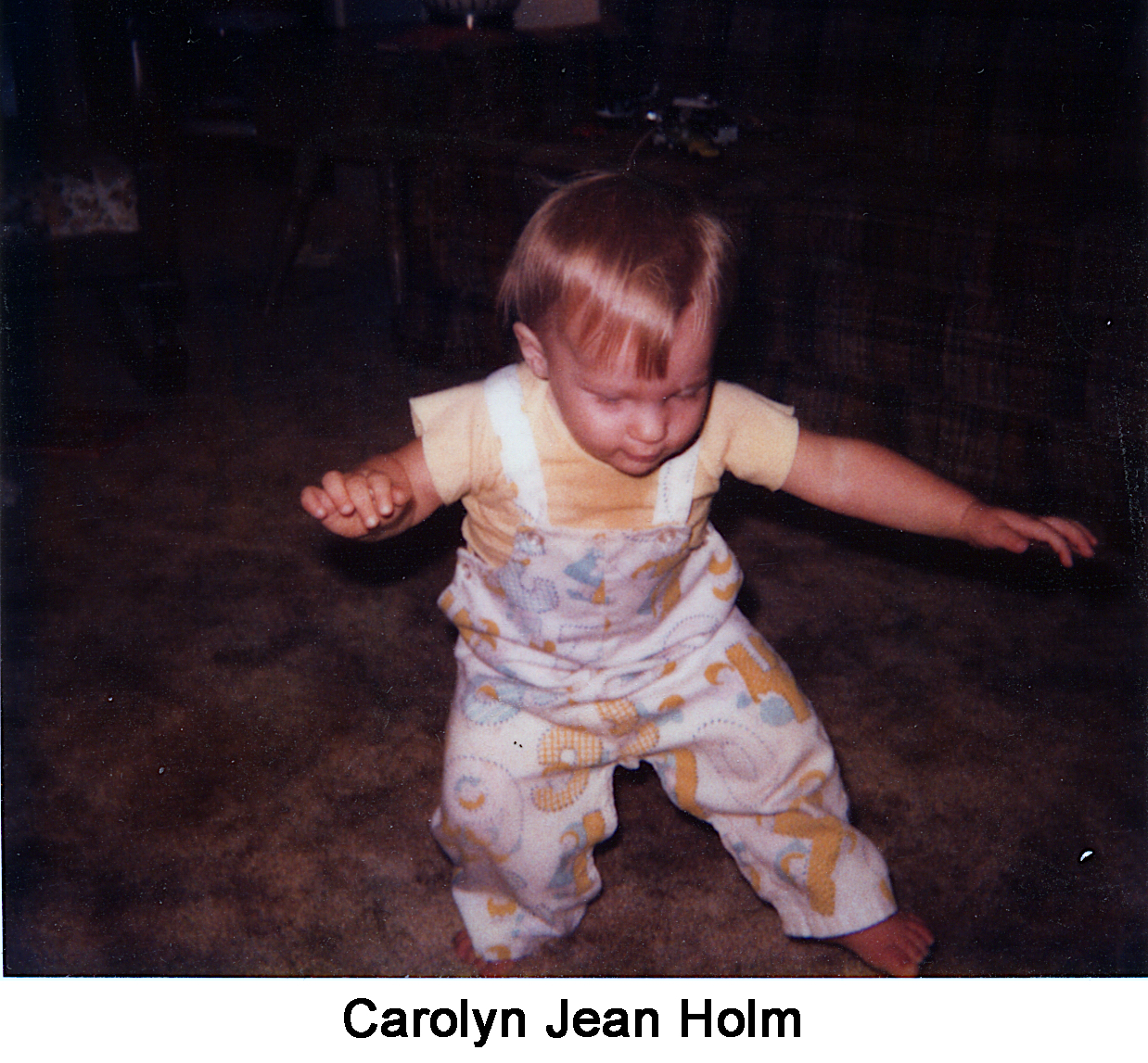 Toddler Carolyn Holm standing with her arms spread