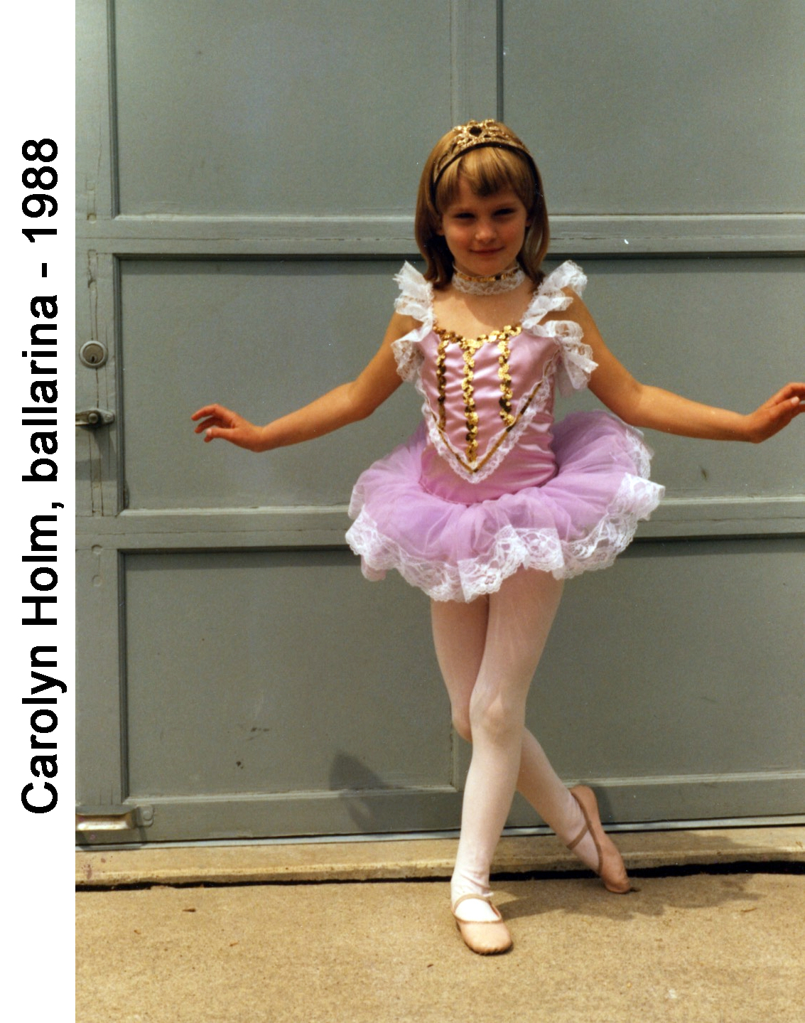 Carolyn Holm posing in her ballarina costume in front of our garage doors