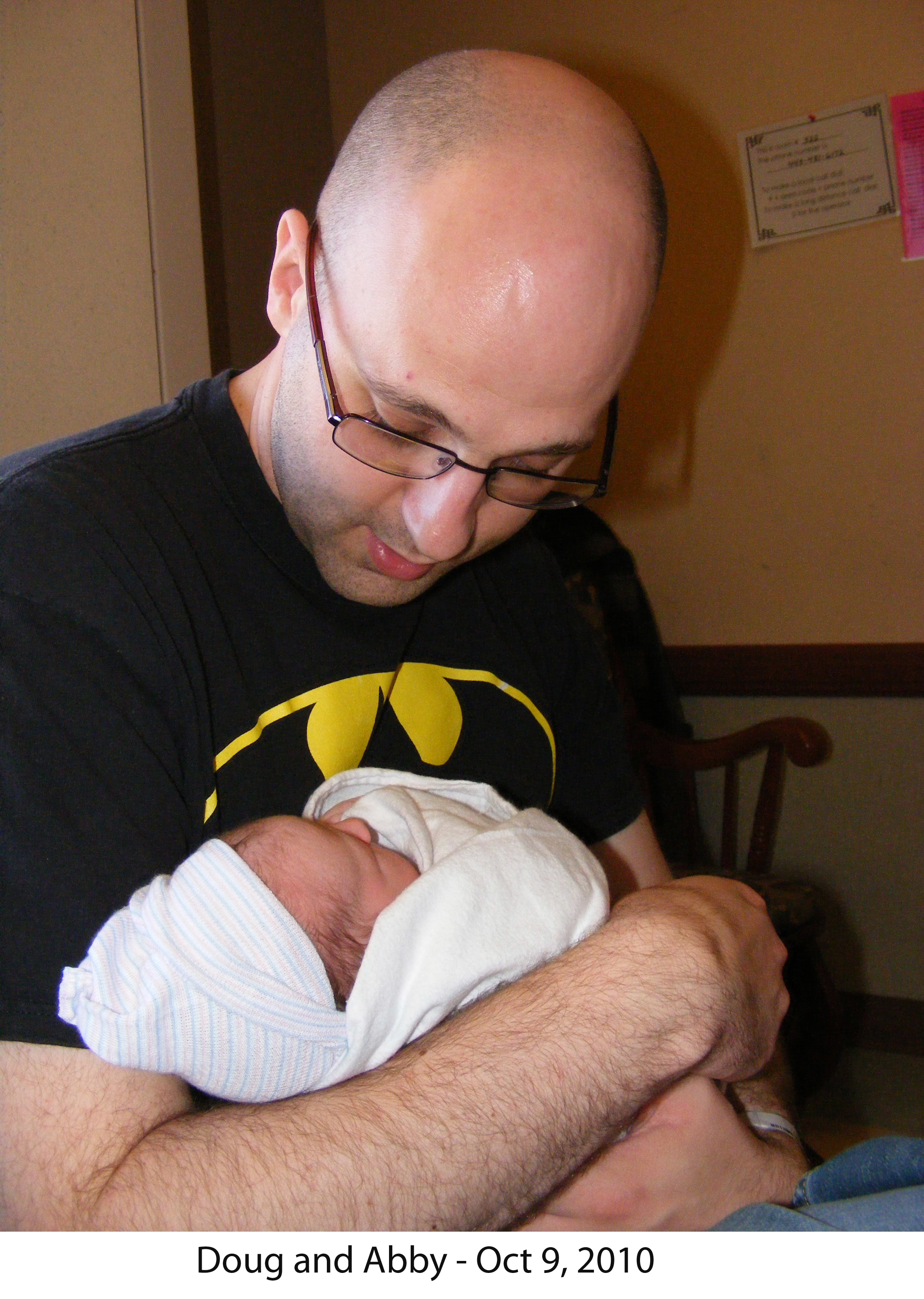 Doug holds and looks at baby Abby on the afternoon of her birth.