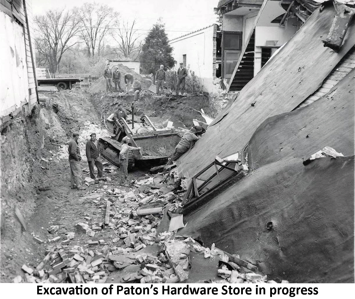 Seen from the opposite direction of the previous photo, this shows
             a bulldozer clearing the debris. Several men are working in the
             hole and others are watching the work.