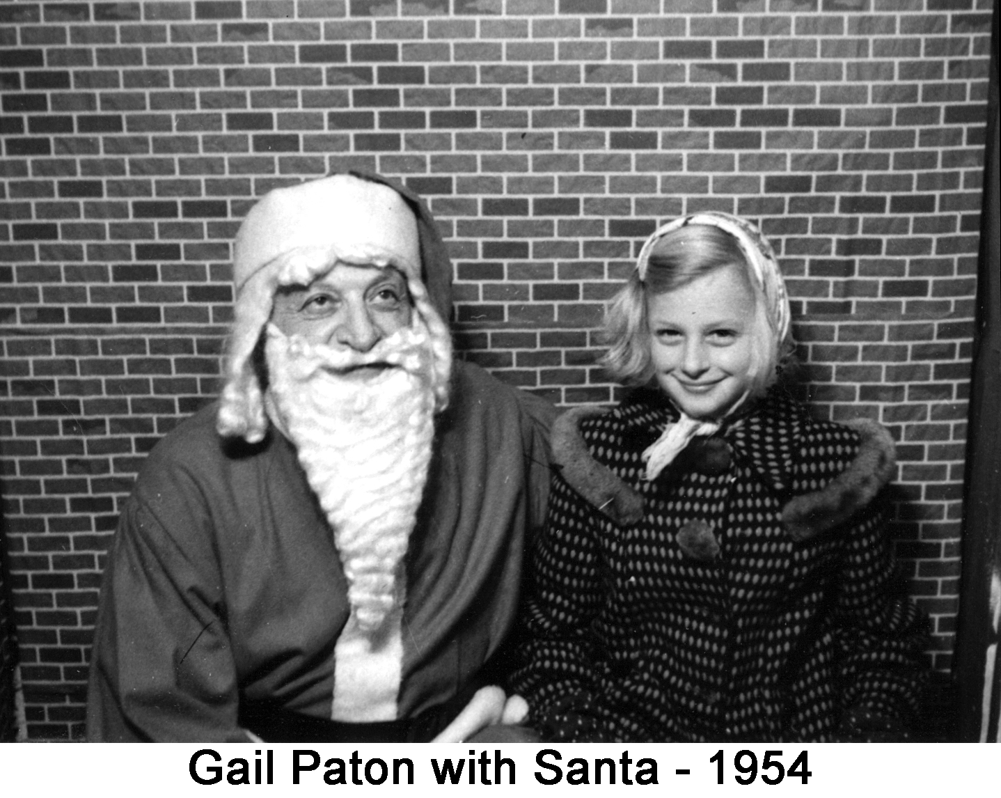 A Santa worker and Gail Paton sitting in front of a brick wall
