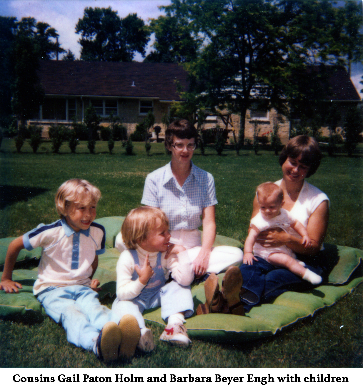 Gail Holm and Barb Engh sitting on a blanket with their children