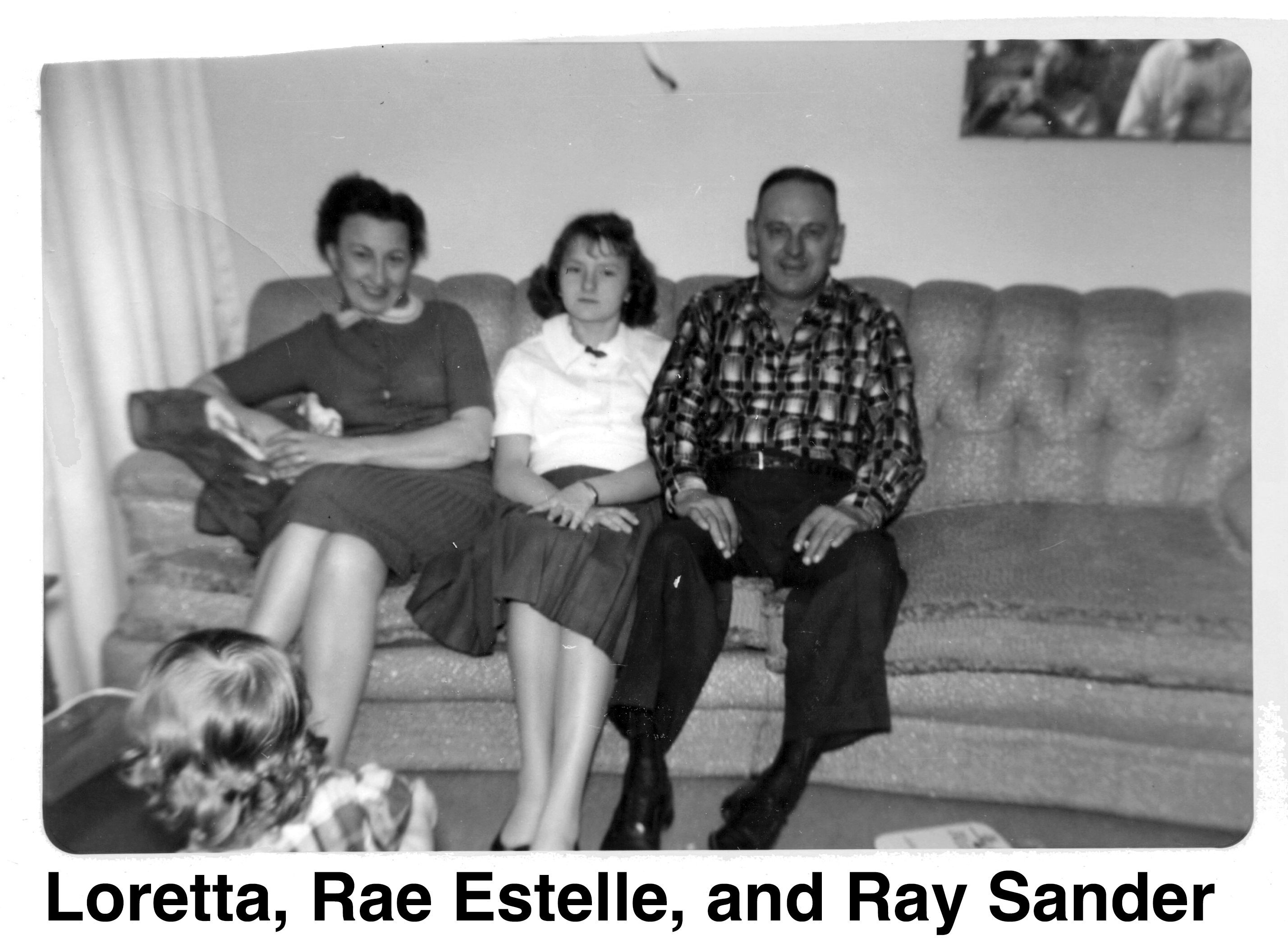 The three of them are seated on a sofa.