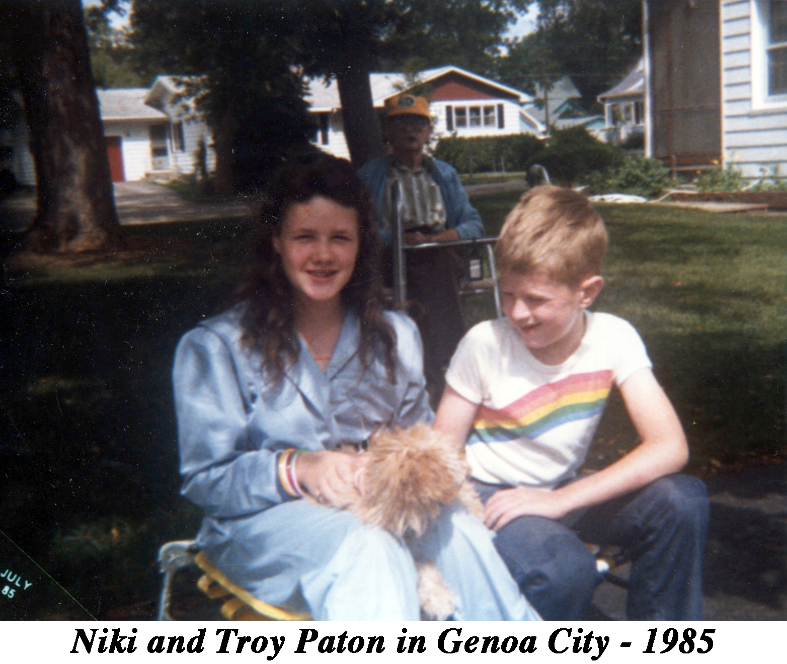 Niki and Troy Paton sitting with a puppy in Genoa City, WI. Bob Paton is 
           sitting in the background.