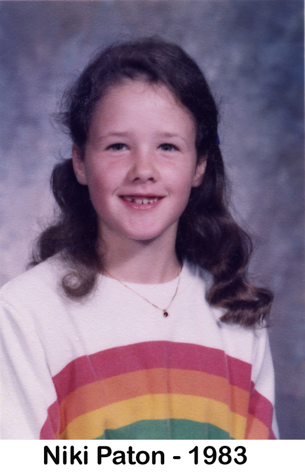 Niki Paton in 1983 at age 8 in a school photo wearing a rainbow-colored shirt