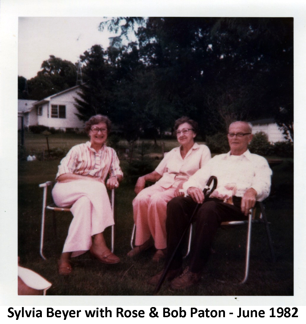 Sylvia Beyer, Rose Paton, and Bob Paton sitting on lawn chairs in the Paton’s
           side yard.