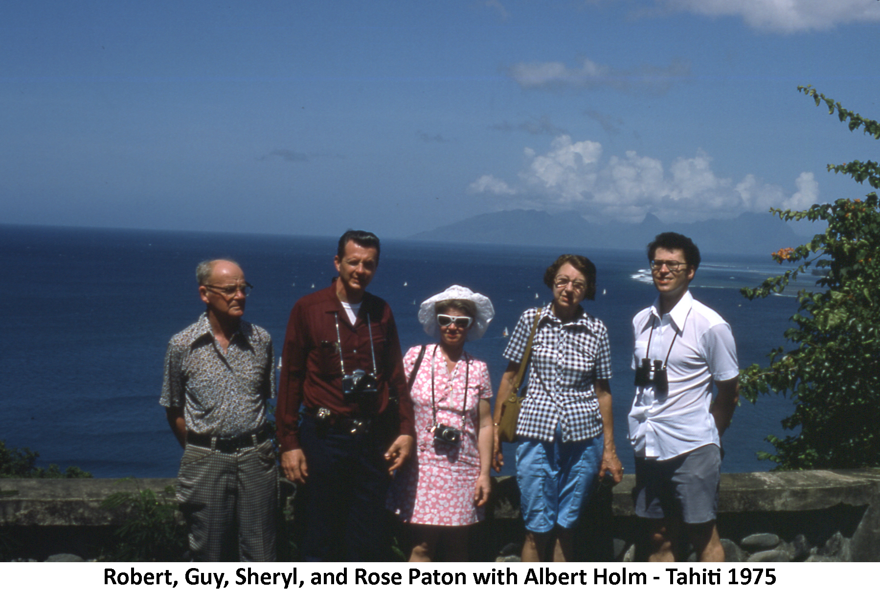 Bob & Rose and Guy & Sheryl Paton and Al Holm standing in front of the ocean 
         dotted with sailboats and a high island in the distance