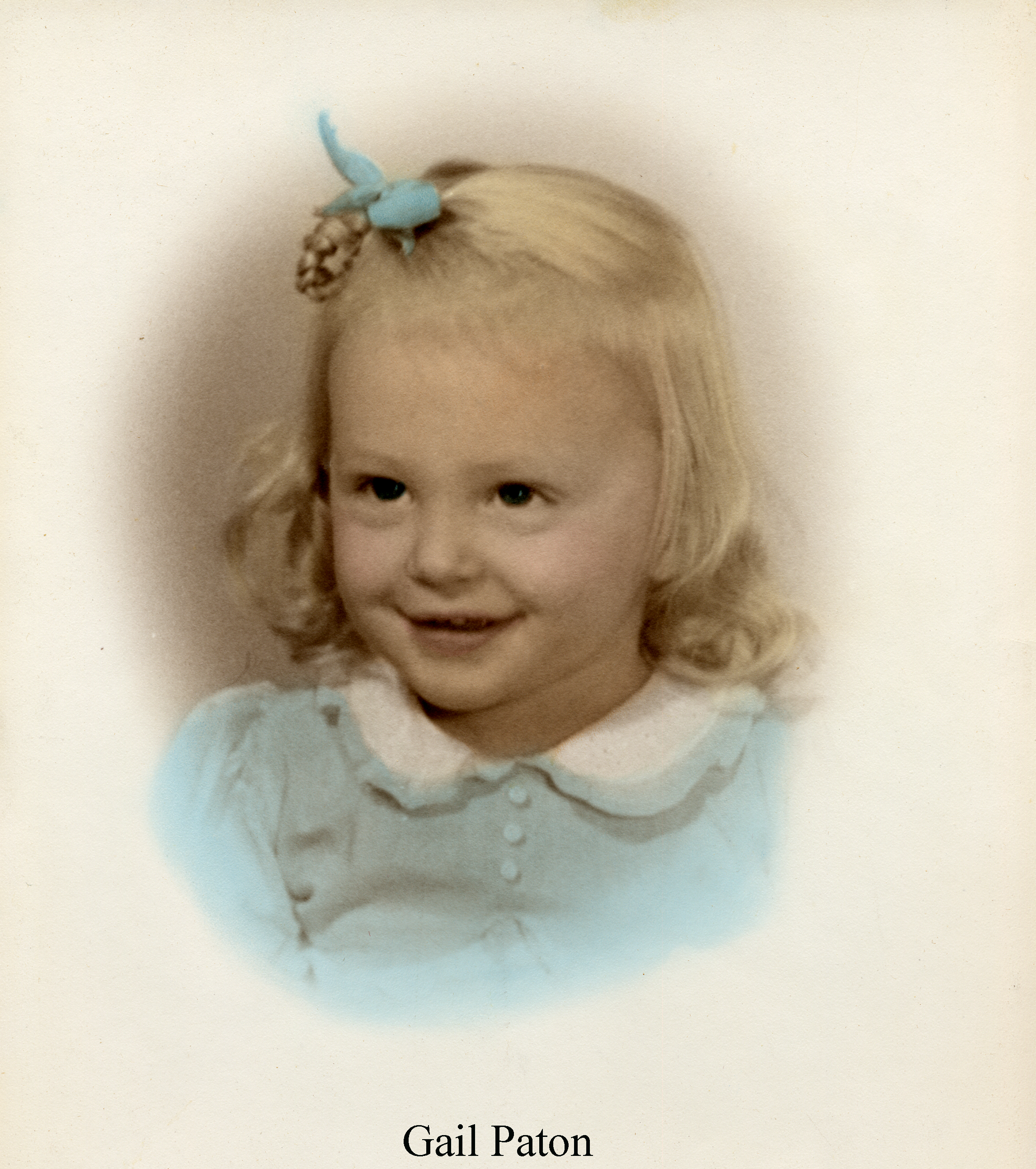 Studio photo of a smiling Gail Doris Paton in a blue dress 
              and with a blue ribbon in her hair