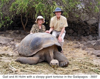 Gail and Al Holm posing with a sleeping giant tortoise on Santa Cruz Island