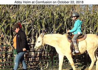 Abigail Holm riding on a horse at a corn maze