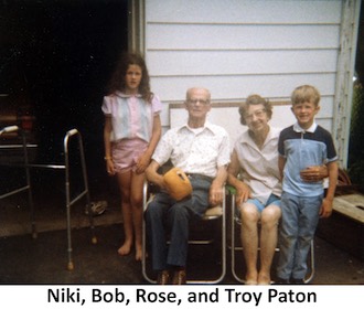 Bob and Rose Paton sitting on lawn chairs with their           grandchildren Niki and Troy Paton standing beside them