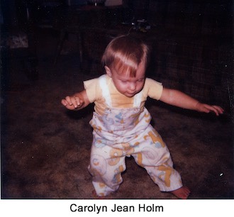 Toddler Carolyn Holm standing with her arms spread