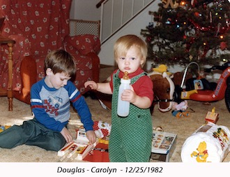 Douglas and CJ amidst their toys in front of the Christmas tree in 1982
