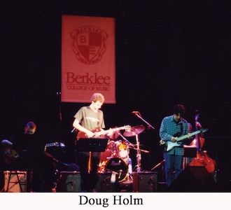 Doug Holm with his guitar on stage at Berklee College