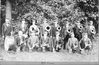 Members of the band are in two rows; Fred Henjes kneels in the front row
