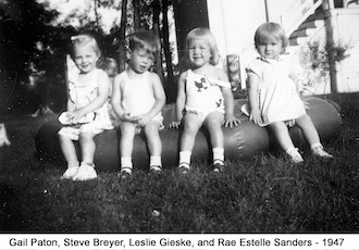 Gail Paton at age 1 1/2 years sitting on a baby pool with three of her cousins
              in July 1947