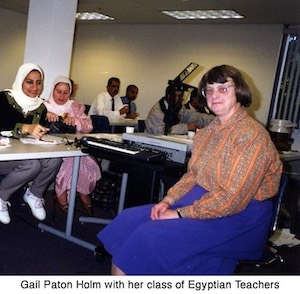 Gail Holm is sitting in a classroom with female and male Egyptian teachers