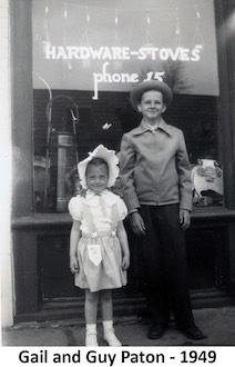 Gail and Guy Paton standing in front of the hardware store window.              Phone number 15. 