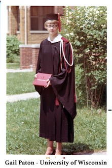 Gail Paton in her graduation robe and cap, and holding a diploma case