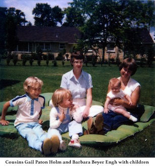 Gail Holm and Barb Engh sitting on a blanket with their children