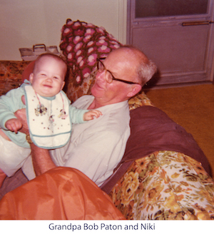Bob Paton holds granddaughter Niki in his living room
