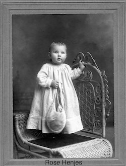 Baby Rose Henjes standing on a chair for her portrait