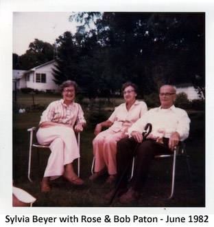 Sylvia Beyer, Rose Paton, and Bob Paton sitting on lawn chairs in the Paton’s           side yard.