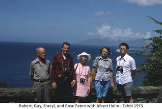 The Patons and Al Holm standing in front of a wall overlooking the ocean in Tahiti