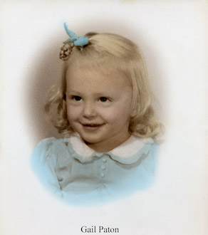 Studio photo of a smiling Gail Doris Paton in a blue dress               and with a blue ribbon in her hair