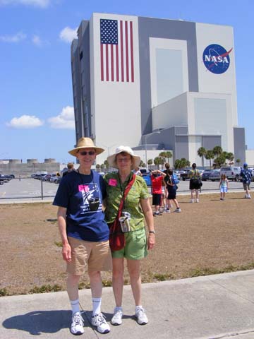 Al and Gail Holm standing in front 
of, but still at a distance from the 525-foot tall Vertical Assembly Building