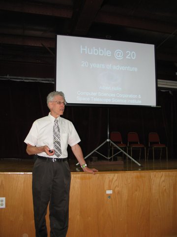Al standing in front of the stage at the
               Iron County Historical Museum. A projection
               screen is on the stage.