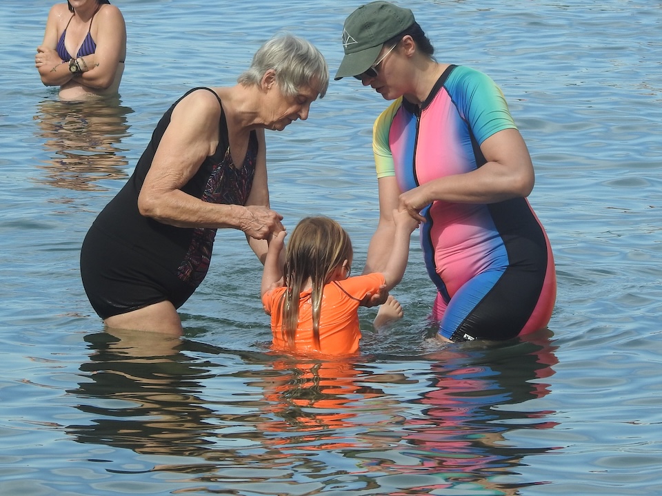 Gail and CJ swing Morgan in the water